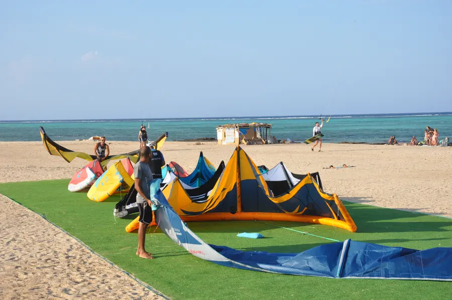 Colourful kites spread on the sand ready for lessons