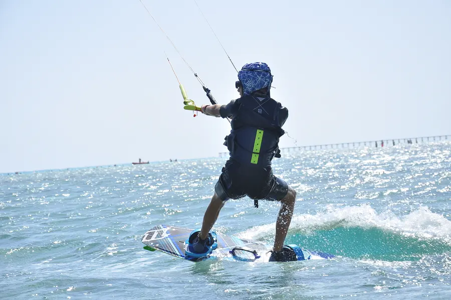 Kitesurfer riding across sparkling blue water at Marsa Alam