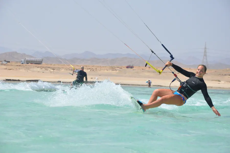 Kitesurfer riding fast across the Red Sea with a wake behind the board